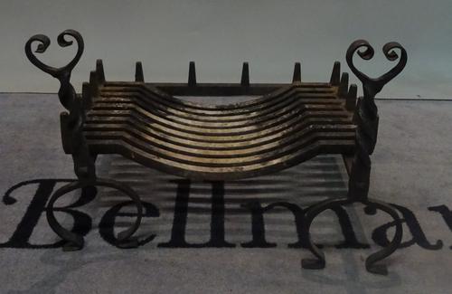 An early 20th century wrought iron fire basket, 60cm wide, and a pair of wrought iron twisted fire dogs, 46cm high (3).