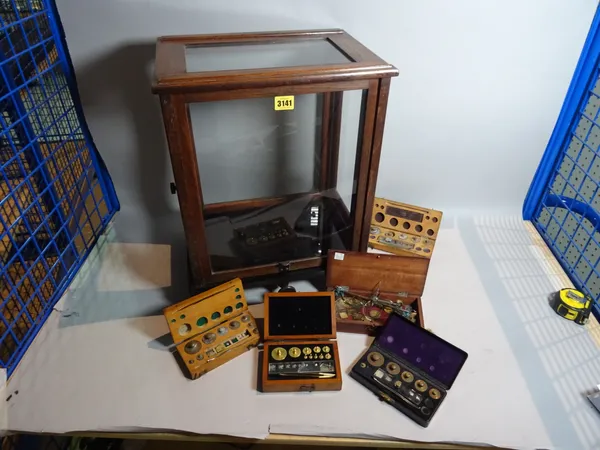 An early 20th century mahogany Chemist's scales, cased, a group of five cased weights (6).