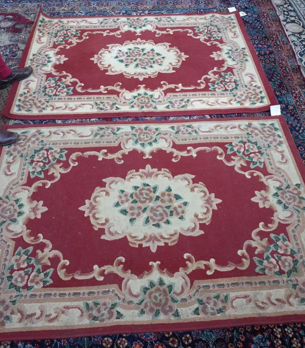 Two machine made red and cream floral rugs, each 170cm x 120cm.