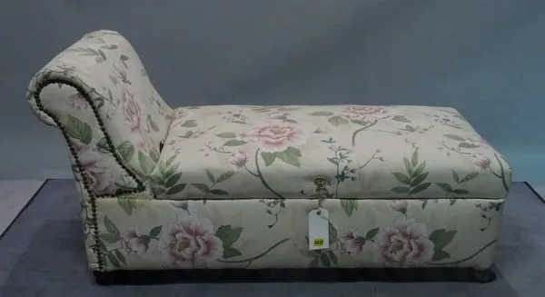 An early 20th century ottoman with roll over arm and floral upholstery, 123cm wide x 69cm high.