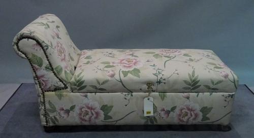 An early 20th century ottoman with roll over arm and floral upholstery, 123cm wide x 69cm high.