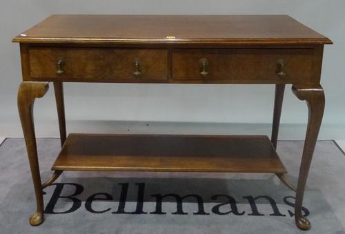 An 18th century style walnut two drawer side table on cabriole supports, united by platform undertier, 121cm wide x 95cm high.
