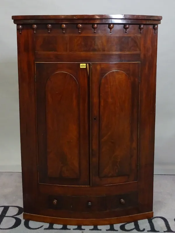 A 19th century mahogany hanging corner cupboard with moulded arch doors and single drawer base, 86cm wide x 126cm high.