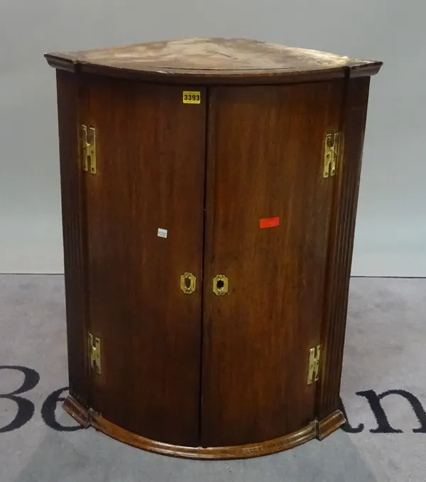 An 18th century oak bowfront hanging two door cupboard, 66cm wide x 84cm high.