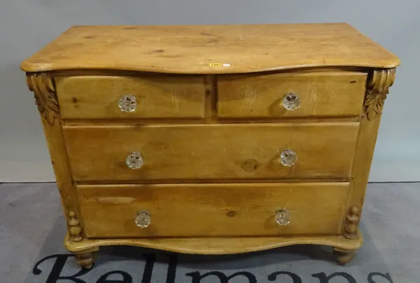 An early 20th century pine serpentine chest of two short and two long drawers on turned supports, 104cm wide x 76cm high.