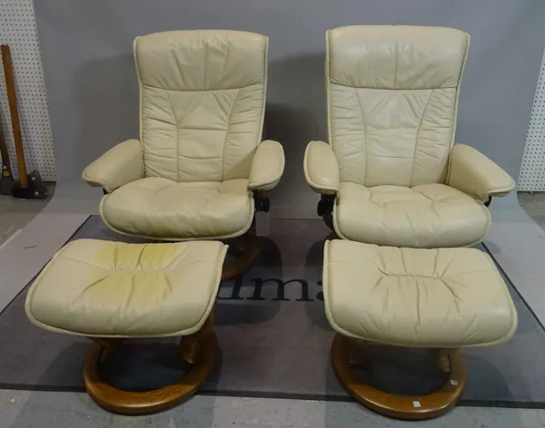 EKORNES; A pair of modern reclining armchairs with white leather upholstery on swivel circular bases, 76cm wide x 96cm high, with two matching footsto