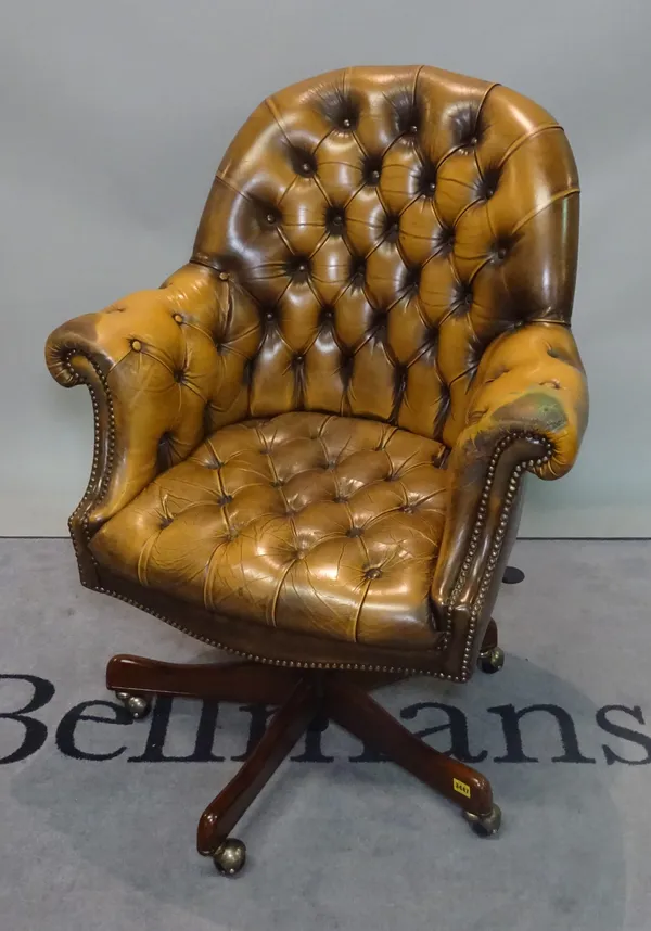 A modern hardwood framed office armchair with tan leather, button back upholstery, 80cm wide x 100cm high.