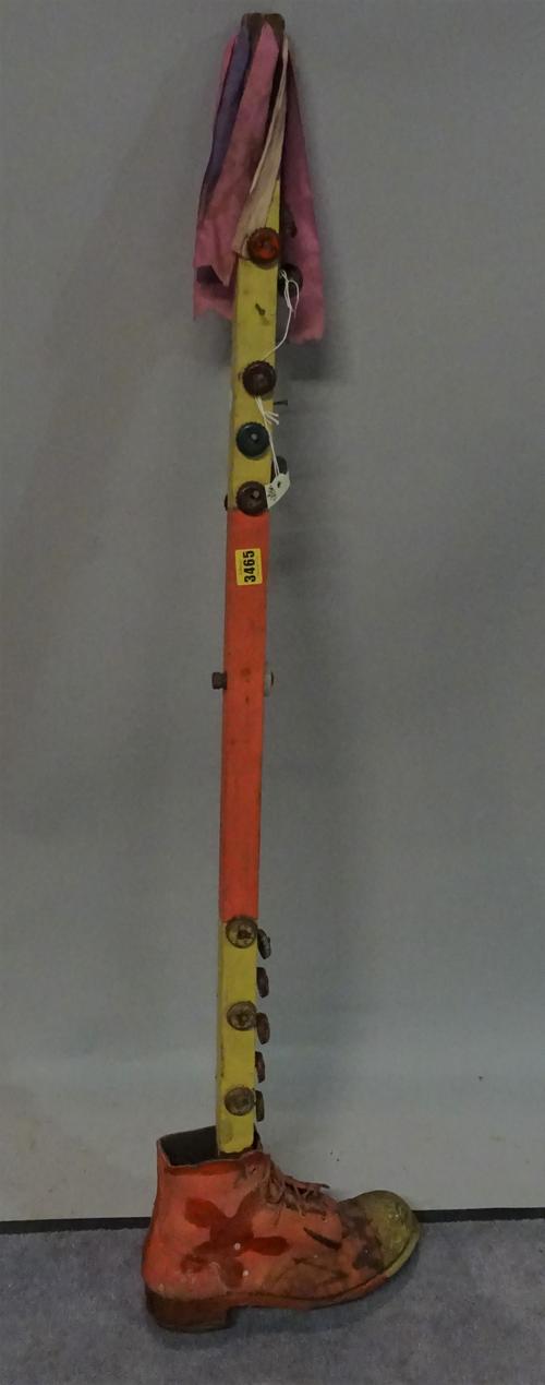 20th century, a morris dancers tipstaff decorated with bottle tops, with a single shoe for the base, 118cm tall.