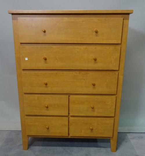 A modern hardwood tall chest with mirrored back over three long and four short drawers, 90cm wide x 120cm high.