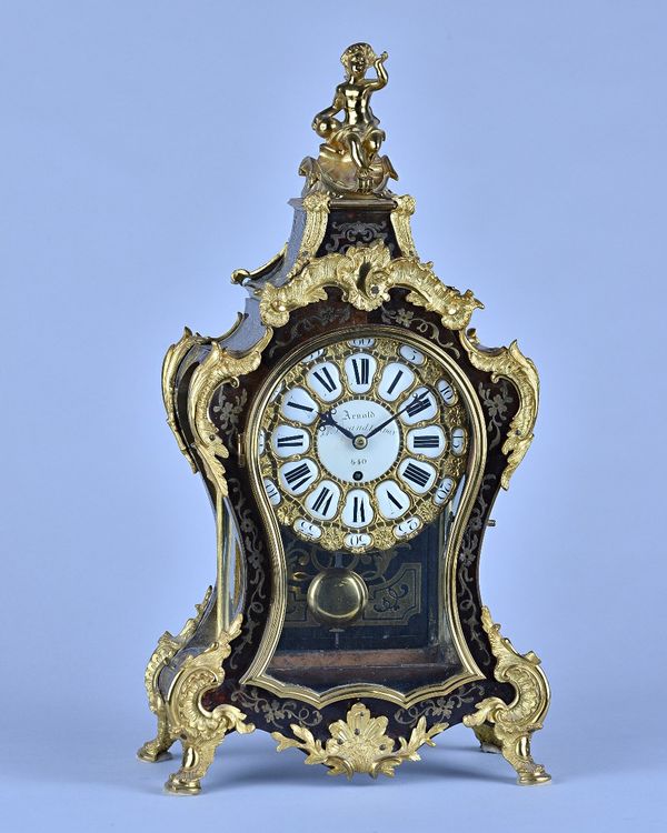 An English boulle work mantel timepieceIn the Louis XV style, By Arnold, 84 Strand, London, No. 540 The shaped case surmounted by a seated cherub, abo