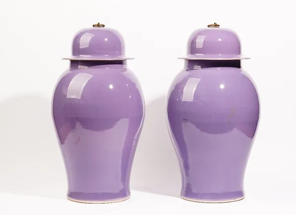 A pair of modern baluster vases and covers, with a lilac ground and having brass ring handles, 55cm high.