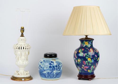 A white glazed pottery table lamp on a circular gilt painted base, 44cm high, a blue ground ceramic baluster table lamp decorated with butterflies, 36