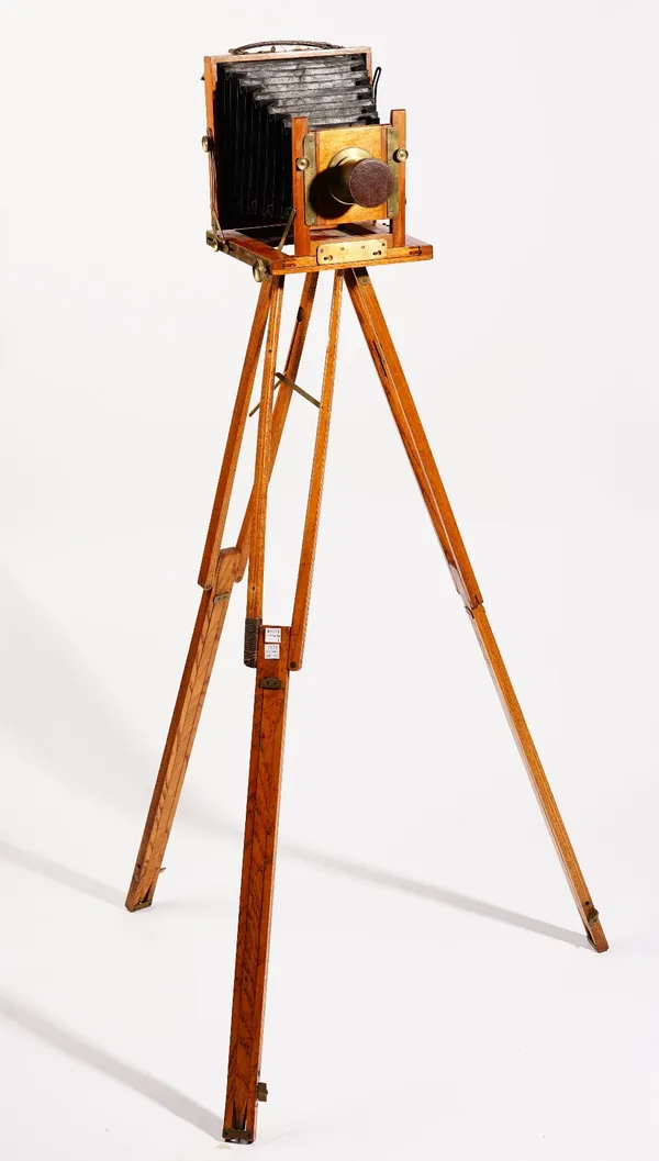 A mahogany cased plate camera, early 20th century, with a three section oak stand.