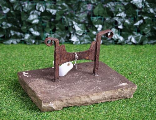 A wrought iron boot scraper on stone mount, 39cm wide x 25cm high.