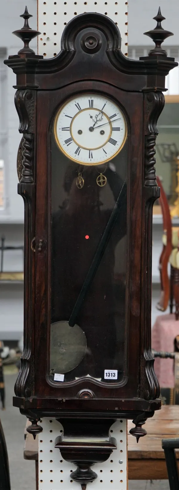 A late 19th century mahogany Vienna style regulator wall clock, the arched top with turned finials, the two-part dial with Roman numerals, 125cm high,