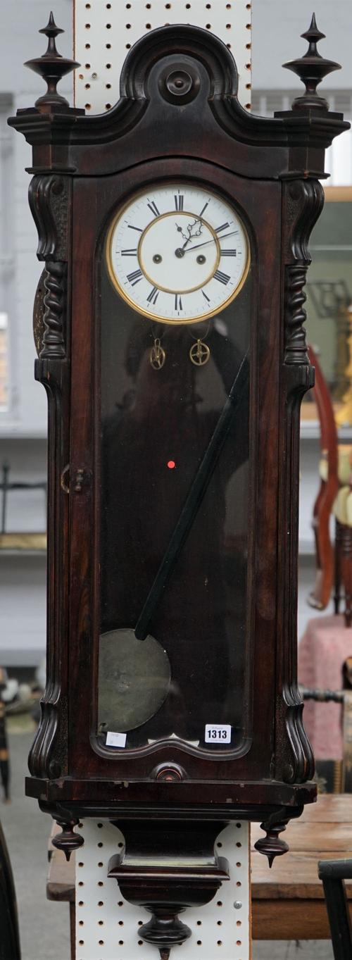 A late 19th century mahogany Vienna style regulator wall clock, the arched top with turned finials, the two-part dial with Roman numerals, 125cm high,