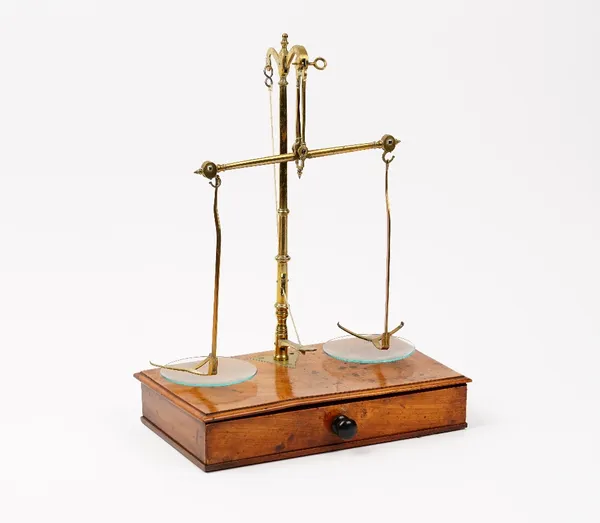 A pharmacist's Victorian walnut and brass set of beam scales, the drawer fitted with the weights, 27cm wide.