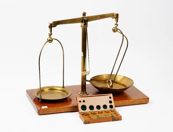 A set of Maw Class B brass beam scales, on a wooden base, 50.5cm wide, and a cased set of weights labelled 'F E Becker & Co'.