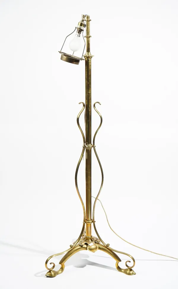 An Art Nouveau brass standard lamp, originally an oil lamp with telescopic cylindrical column and scrolled tripod base, 145cm high, adapted for electr