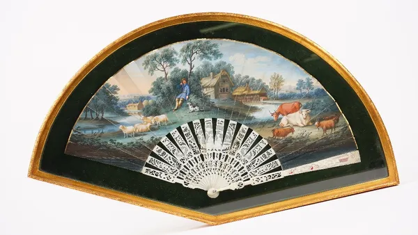 A Continental painted paper fan, late 18th century, the leaf hand-painted depicting a farmyard scene mounted on carved and pierced bone sticks, framed