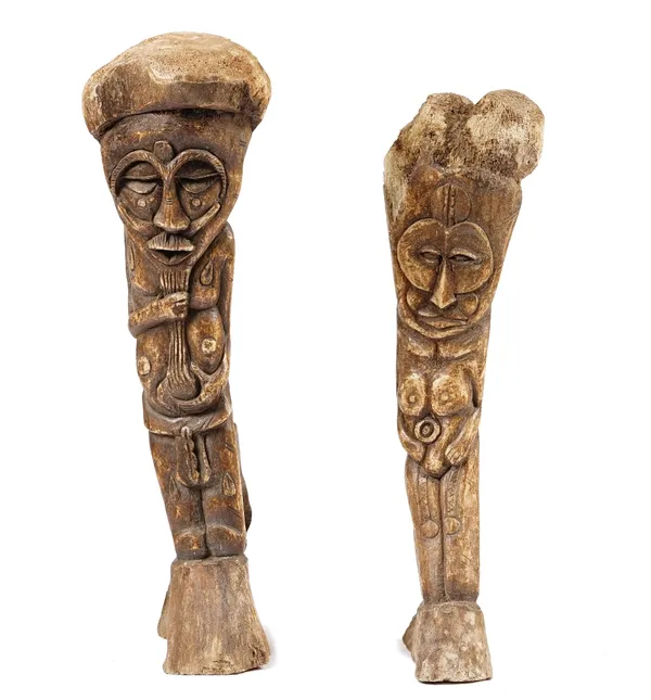 An Inuit whale bone carving of a tribal figure, 56cm high, together with another smaller example. (2).