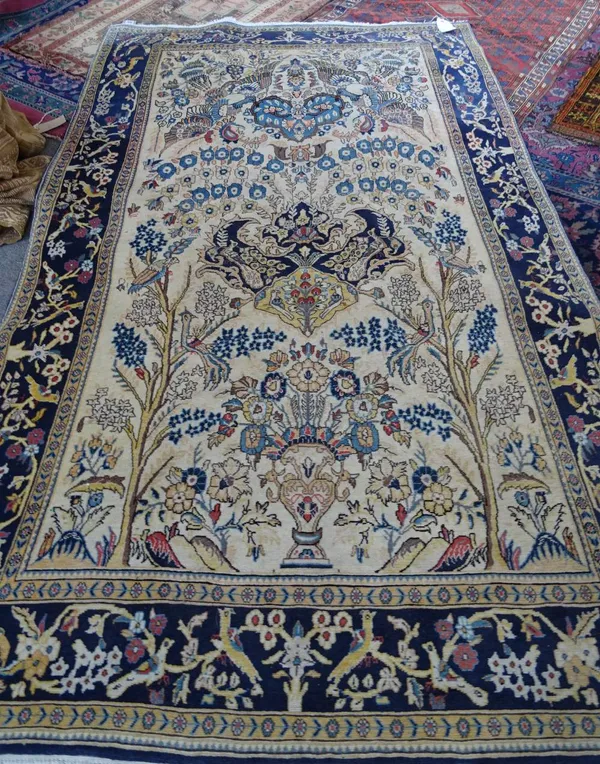 A Sariugh rug, Persian, the ivory field with a bold indigo and saffron medallion rising to a pair of birds, floral sprays and trees; a dark indigo bir