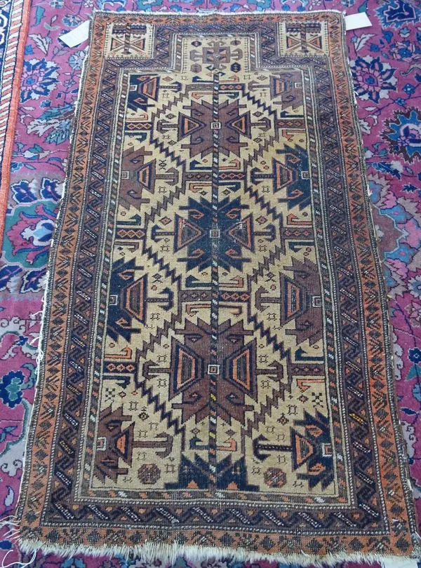 A Beluchistan prayer rug, the pale caramel mehrab with three stylised medallions, smaller motif to arch, plant spandrels, twin borders, 127cm x 69cm.