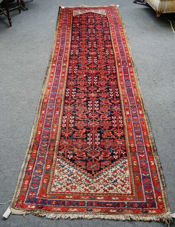 A Hamadan runner, Persian, the dark indigo field with an allover herate design, ivory ends; three borders, 408cm x 105cm.