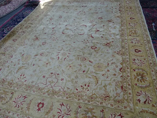 A carpet of Persian design, the ivory field with palmettes and floral sprays; a yellow palmette border, 368cm x 276cm.