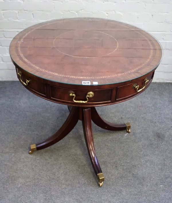 A George III style mahogany drum table with six dummy and one true frieze drawer, on four downswept supports, 76cm diameter x 76cm high.