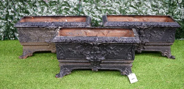 A set of three black painted cast iron rectangular planters with relief floral cast decoration, 72cm wide x 40cm high.