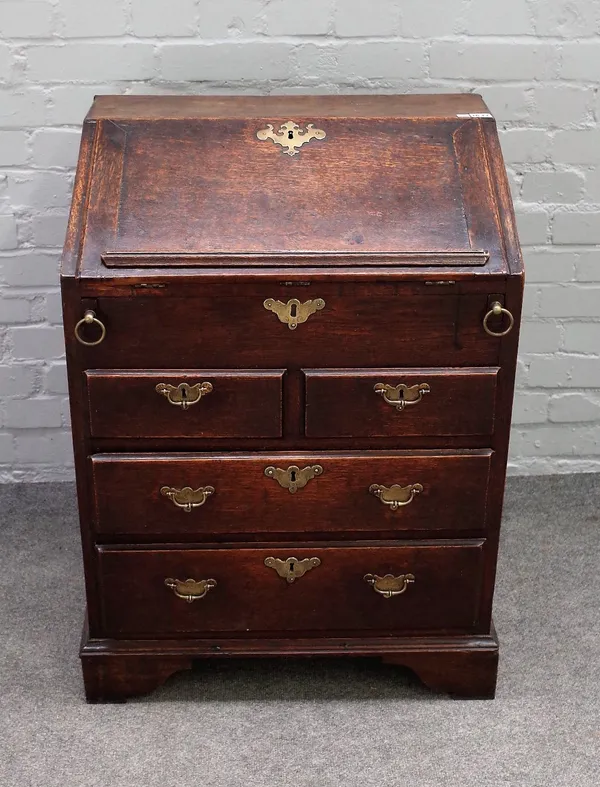 A small 18th century oak bureau, the stepped and welled interior over two short and two long drawers on bracket feet, 66cm wide x 85cm high.