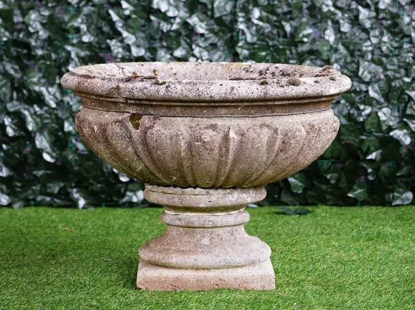 A reconstituted stone oval jardiniere with lobed body on turned socle, 66cm wide x 50cm high.