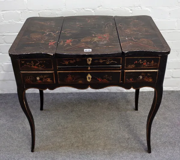 A Louis XV style japanned poudreuse, 19th century, chinoiserie decorated on a black ground and gilded, the divided hinged top of shaped outline enclos