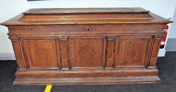 A 16th century Italian marquetry inlaid walnut and fruitwood cassone, the raised lift caddy top over triple panelled front divided by stop fluted pila