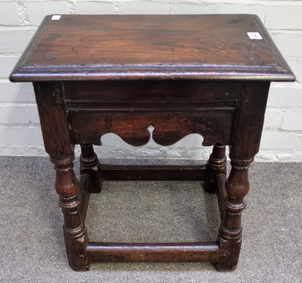 An oak joint stool, 17th century, the rectangular top with stepped moulded edge, having wavy aprons, on baluster turned and square section legs united