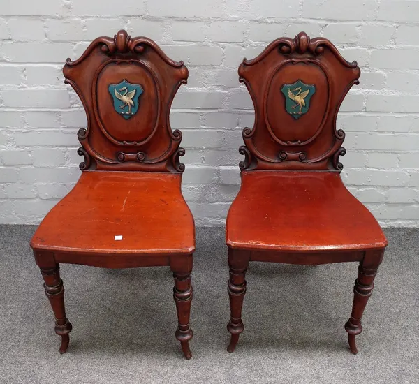 A pair of early 19th century mahogany cartouche back hall chairs, polychrome painted with an egret on turned supports, 43cm wide x 85cm high, (2).