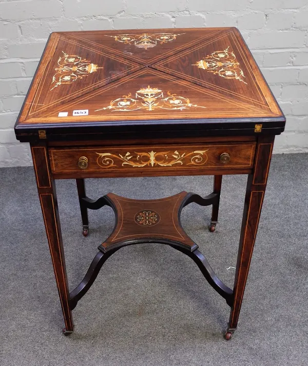 An Edwardian marquetry inlaid mahogany and rosewood envelope card table on tapering square supports, 56cm wide x 74cm high.