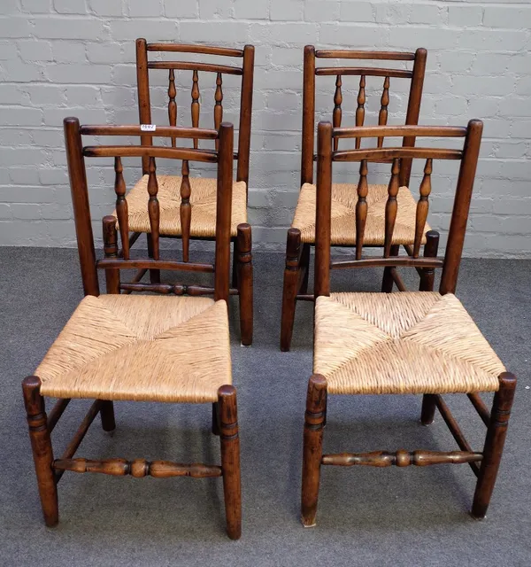 A set of four ash and elm spindle back chairs, early 19th century, with three baluster turnings, rush seats, on turned legs united by stretchers, 45cm