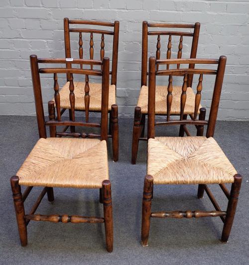 A set of four ash and elm spindle back chairs, early 19th century, with three baluster turnings, rush seats, on turned legs united by stretchers, 45cm
