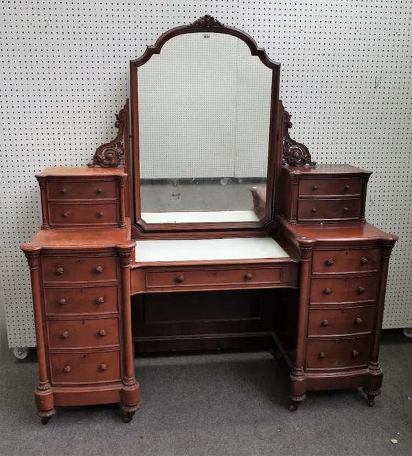 A Victorian Duchess style walnut dressing table, with a swing mirror over an arrangement of thirteen drawers flanked by turned columns, 160cm wide x 1