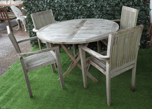 A teak circular garden table on folding X frame base, 121cm dia x 77cm high, together with four matching armchairs, 64cm wide x 92cm high.