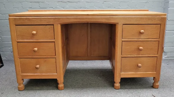 Robert Mouseman Thompson; A 20th century blonde oak dressing table with six drawers about the knee, on octagonal supports, 137cm wide x 72cm high.