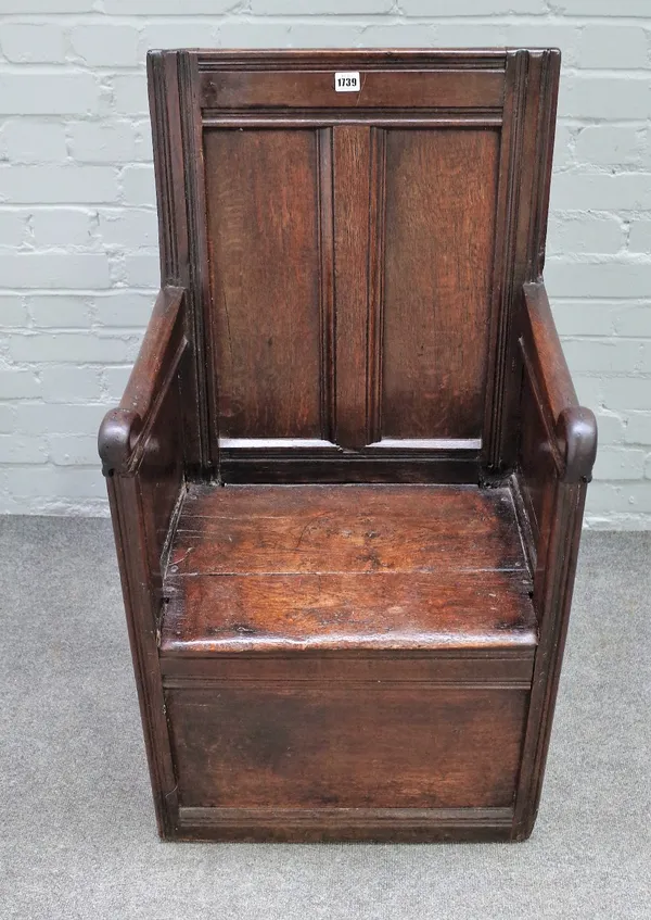 A 17th century oak lambing style chair of enclosed panel construction, 54cm wide x 98cm high.