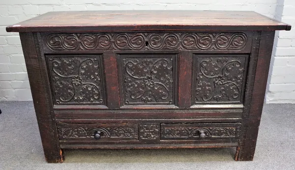 A late 17th century and later oak mule chest, of panelled construction, with hinged top, the foliate carved front with two drawers on extended stiles,