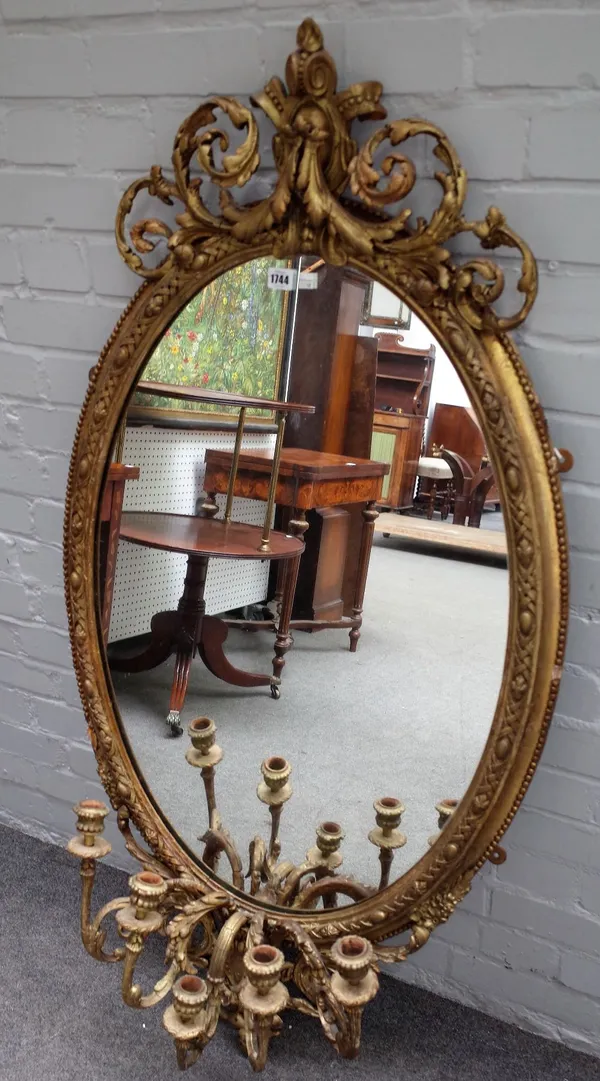 A 19th century gilt framed oval mirror with acanthus swag, cartouche crest and five branch lower frieze, 70cm wide x 135cm high.