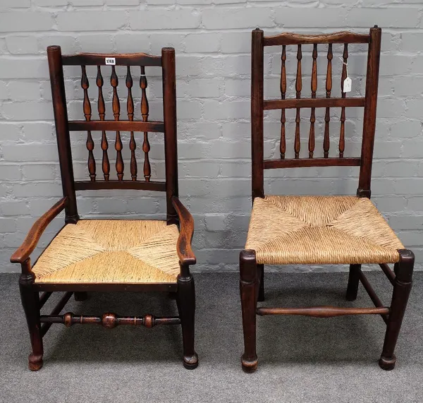 Two Lancashire spindle back ash and elm chairs, 19th century, one with arms, having rush seats, on rounded legs united by stretchers (2).