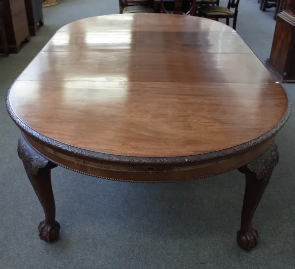 A late 19th century mahogany circular extending dining table, on carved cabriole supports, on claw and ball feet, two extra leaves, 146cm diameter x 2