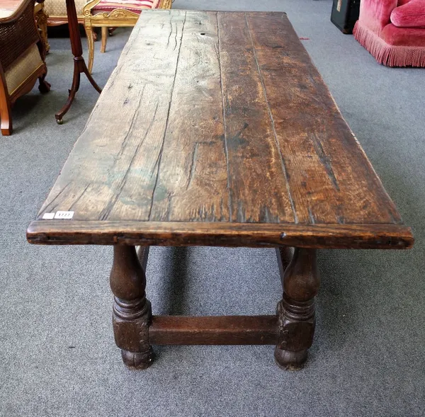 A 17th century and later oak refectory table, the cleated top on baluster turned supports, united by stretcher, 69cm wide x 188cm long.