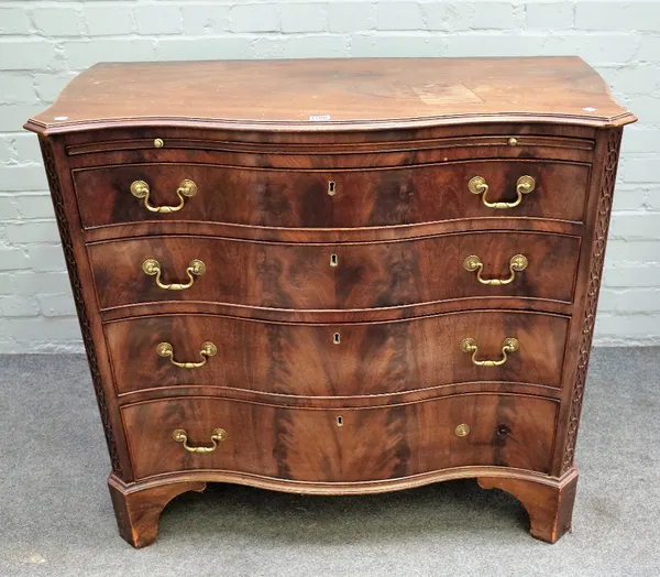 A George III style serpentine mahogany chest, the brushing slide over four long graduated drawers, flanked by canted blind fret corners, 104cm wide x